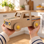 Child holding up a finished cardboard car with bolt wheels